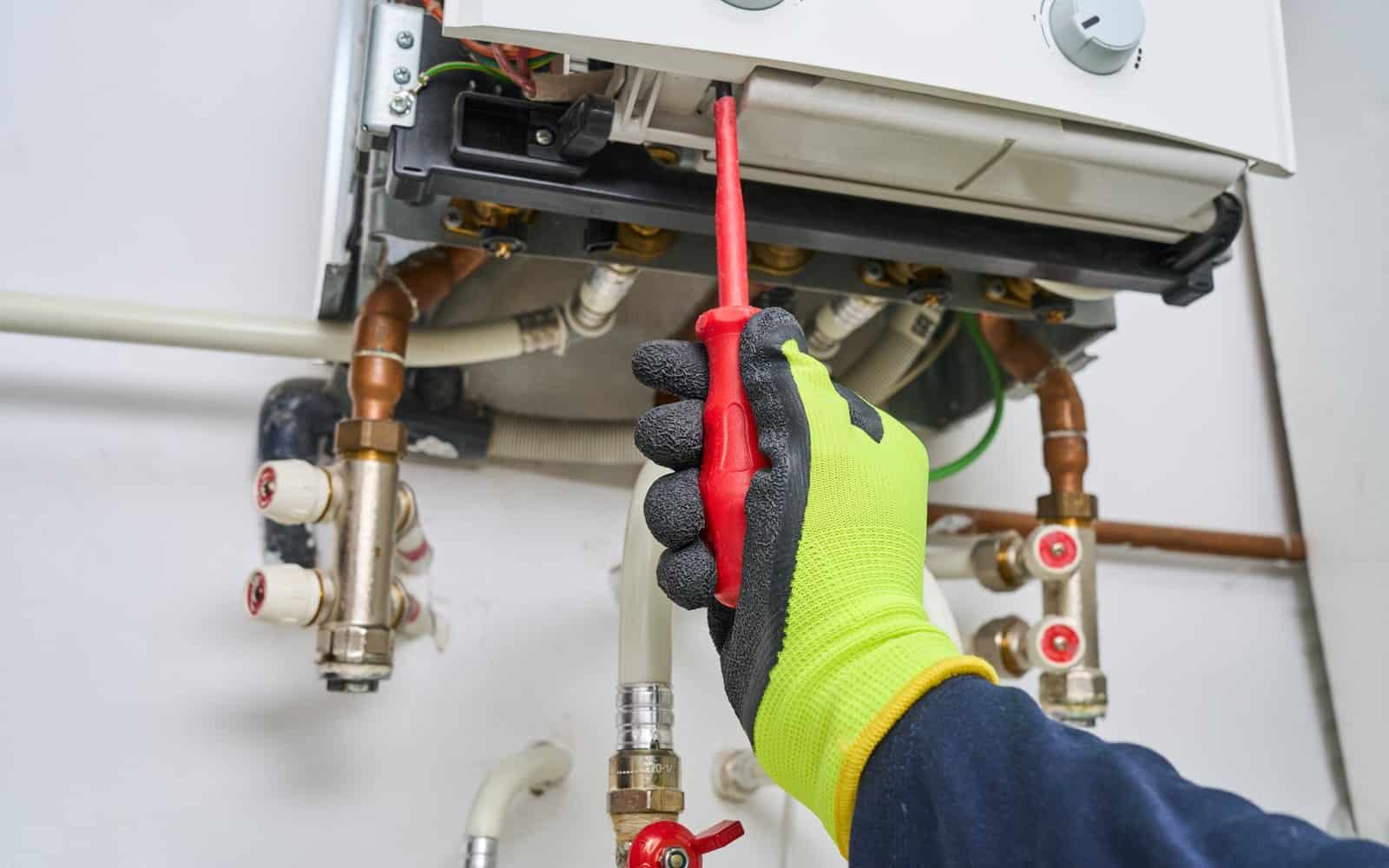 Engineer checking boiler pipework and heating controls