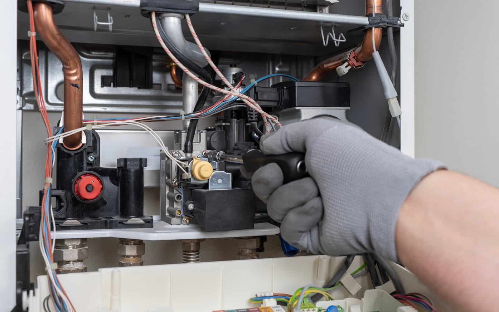 Engineer installing connections beneath a domestic boiler in Southampton