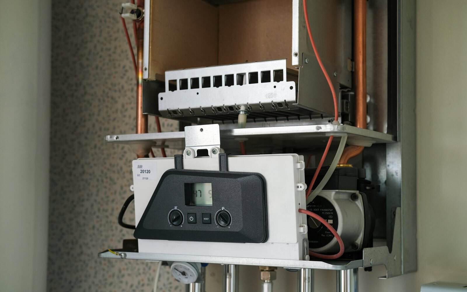 Engineer checking boiler pipework and heating controls